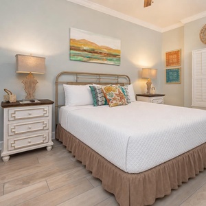 Rest on the plush king bed beneath warm lamps and admire coastal artwork in this master suite