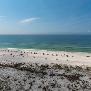 Enjoy stunning views of the beach with colorful umbrellas and inviting waters, perfect for a relaxing day outdoors