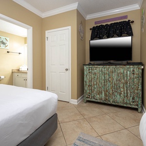 Relax in a cozy guest bedroom featuring two double beds, a flat-screen TV, and charming decor for a restful stay