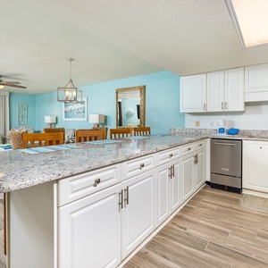 White cabinetry and granite breakfast bar invite you to prepare meals while enjoying the tranquil gulf view