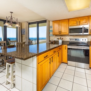 Granite breakfast bar invites casual chats while you savor coastal views from the dining area windows