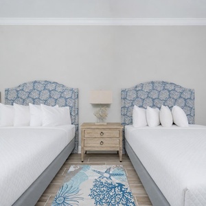 Inviting guest room with two queens, fluffy pillows, and a soothing vibe