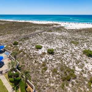 A cooling pool glistens beside shaded lounge chairs as you watch boats glide across the clear gulf waters