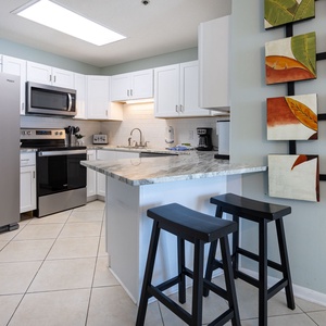 Enjoy cooking in this stylish kitchen with stainless appliances, marbled counters, and sleek cabinetry