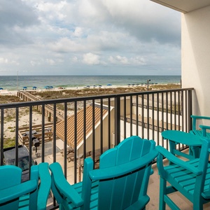 This balcony features bright turquoise chairs, offering a perfect spot to enjoy the beachfront view and relax