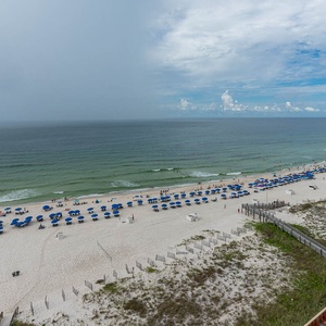 Beachfront view showcasing white sand and vibrant blue umbrellas lining the shore, inviting relaxation and fun