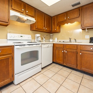 The kitchen features wood cabinetry, white appliances, and a coffee maker for your convenience