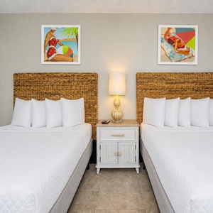 Guest suite with two doubles offers soft pillows and a warm lamp for winding down after coastal adventures