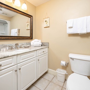 Experience a refreshing start in this guest bathroom, where soft towels await after your coastal adventures