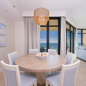 Gather around this round table, sharing laughter while enjoying coastal views through the expansive windows
