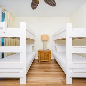 Four twin beds in the bunk room offer cozy spots for the kids to rest after a day of play near the shore