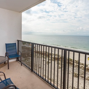 Enjoy a relaxing view from the balcony with comfortable seating and a beautiful beachfront panorama