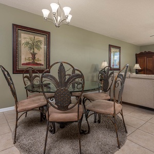 Dine at the elegant glass table surrounded by stylish chairs, perfect for meals and gatherings in this inviting space