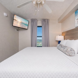 Fluffy pillows invite you to relax in the king suite for a calm movie night after a fun day at the beach