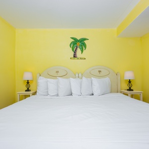This bright room features a comfortable bed with fluffy pillows, perfect for a relaxing getaway