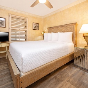 Warm-toned walls with a queen bed and modern furnishings in this guest room, creating a serene retreat with stylish decor