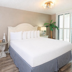 Experience restful nights in this inviting master bedroom with a king bed, stylish decor, and beachfront balcony access