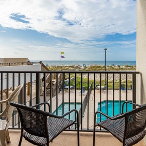 Enjoy a relaxing view from the balcony with seating overlooking the pool and beachfront, perfect for unwinding