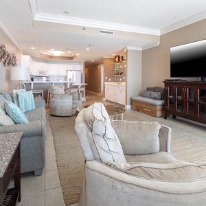 Relax in this inviting living area featuring a cozy seating arrangement, a large TV, and view of the beach