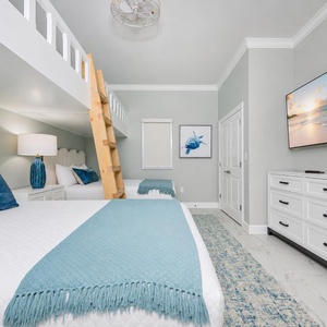 Experience this charming guest bedroom with two queen beds, a cozy loft with two twin beds, and a large TV