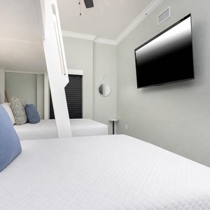 Unwind with a movie in this cozy bunk room with fun colors and two twins lofted above two queen beds