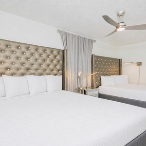 Elegant bedroom featuring plush, tufted headboards adorning two queen beds with cozy bedding, perfect for a restful getaway