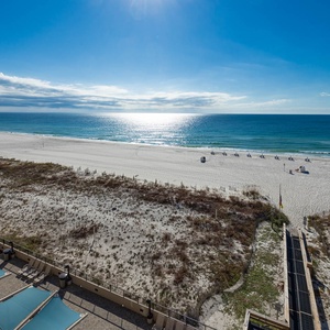 Gaze at the sparkling waters and soft beach from the inviting outdoor seating area below