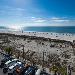 Enjoy a breathtaking beachfront view with vibrant blue waters and white sand, perfect for a relaxing getaway