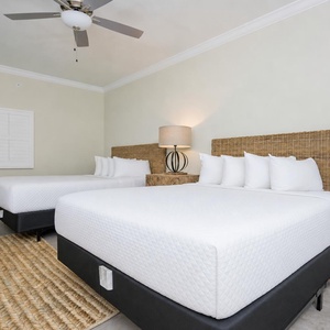 Soothing guest room featuring two queen beds, soft pillows, and stylish decor for a relaxing stay