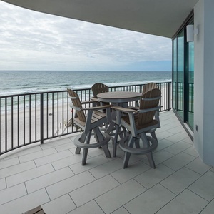 Savor the fresh air at this balcony with a round table and chairs, perfect for enjoying views and relaxing moments