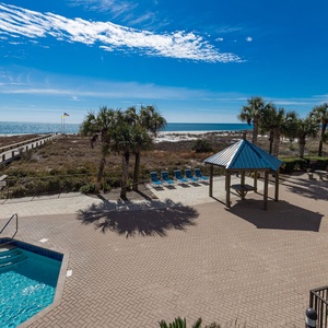 Relax by the inviting pool area, with lounge chairs and easy access to the beach just steps away