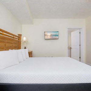 Quiet moments await on the queen bed in the guest suite where gentle lamp glow meets soft linens