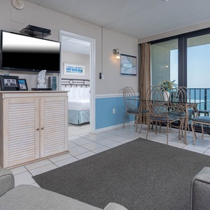This inviting space features a comfortable seating area with a view of the beachfront and a dining table for meals