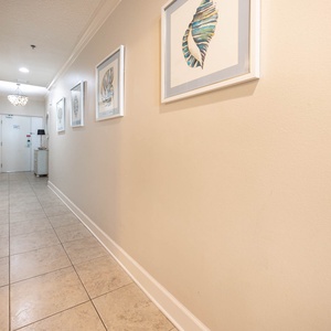 Step into a welcoming hallway adorned with coastal art and elegant lighting, setting the tone for your stay