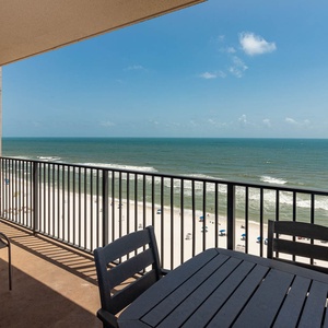 Savor the fresh air on the balcony with seating, overlooking the beach and gentle waves for a relaxing escape