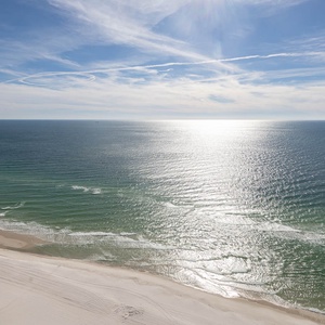 Watch from the balcony as the sun glints on the gulf and the shore curves gently below