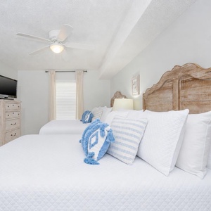 Inviting guest room featuring two comfortable double beds, soft linens, and a TV for your entertainment