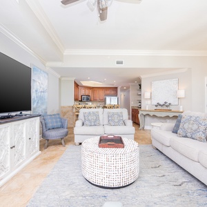 This living area features a large TV, seating with decorative pillows, and a stylish coffee table, creating a welcoming space