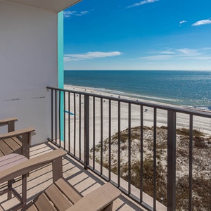 Enjoy stunning beachfront views from this balcony, featuring comfortable seating for relaxation and unwinding