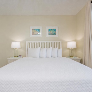 Unwind in the soft, king bed in the master as you relax and enjoy the serene coastal view just beyond your balcony doors