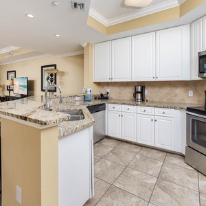 Bright and inviting kitchen with granite countertops, stainless appliances, and a cozy living area featuring plush seating
