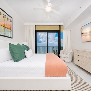 Serene master bedroom featuring a king bed, stylish decor, and captivating beachfront views from the balcony
