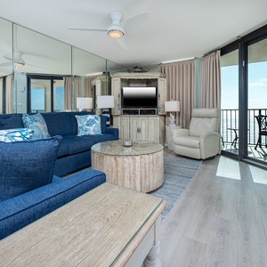 Unwind in the spacious living area with plush seating, a stylish coffee table, and beach views from the balcony