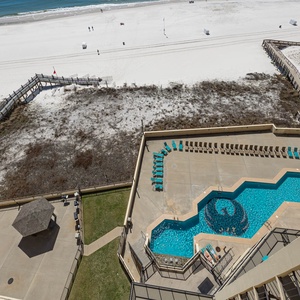 Enjoy a vibrant pool area with turquoise chairs and direct access to the pristine pristine white sand just steps away