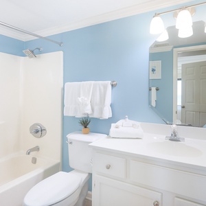 The bathroom features a clean design with a spacious tub and modern fixtures, perfect for a refreshing retreat