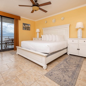 Unwind in the master bedroom featuring a comfortable king bed and direct access to a balcony with beach views