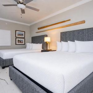 Rest comfortably in this guest room featuring two plush queen beds, stylish decor, and soft lighting