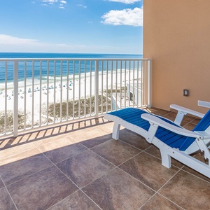 Bask in the sun on the balcony's blue chairs, savoring the gentle sounds of the coast below
