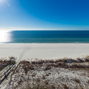 Step onto the boardwalk leading to the beach, where you can enjoy the tranquil waters and bright sunshine