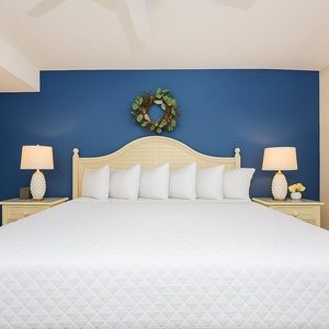 Relax after a day at the beach in this king suite surrounded by fluffy pillows and coastal accents